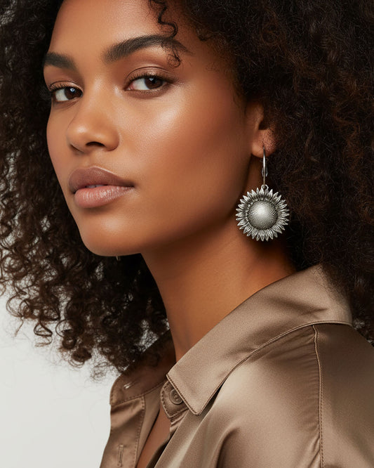 Model wering a pair of silver sunflower earrings