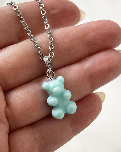 An acrylic turquoise teddy bear pendant on a dainty stainless steel silver chain