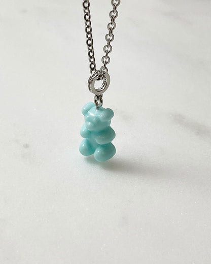 An acrylic turquoise teddy bear pendant on a dainty stainless steel silver chain