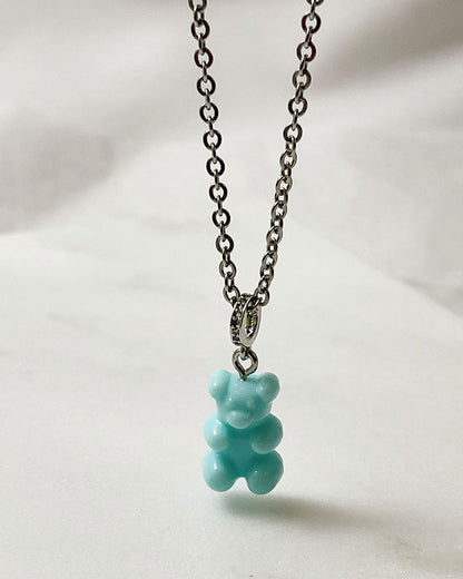 An acrylic turquoise teddy bear pendant on a dainty stainless steel silver chain