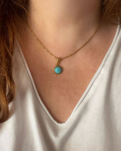 A turquoise pendant necklace in gold