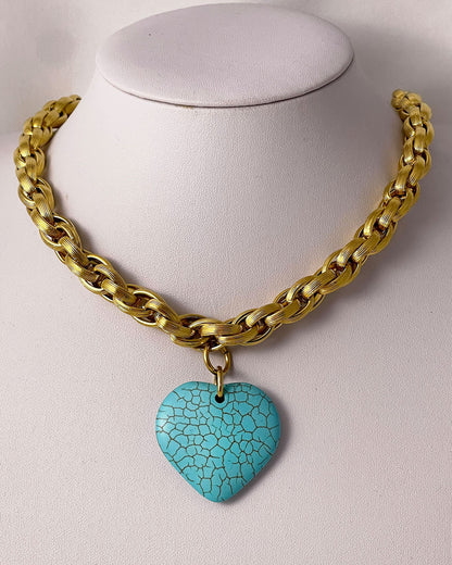A gold chunky chain necklace with a large turquoise heart pendant