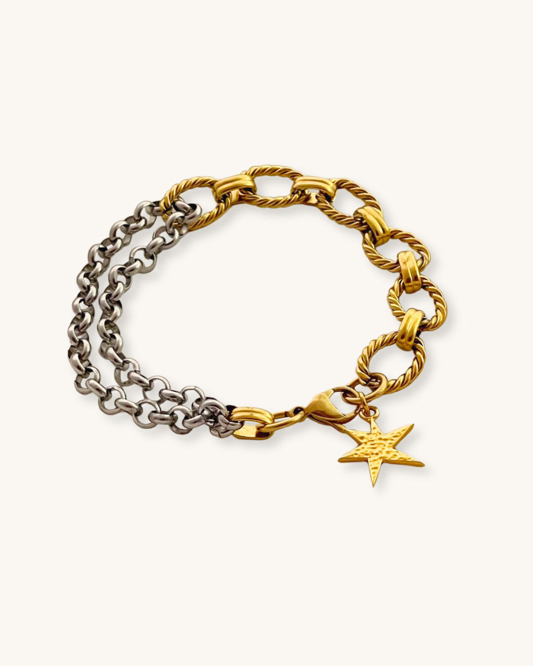 Two chain bracelets, one gold and one silver with a gold charm charm on a light background