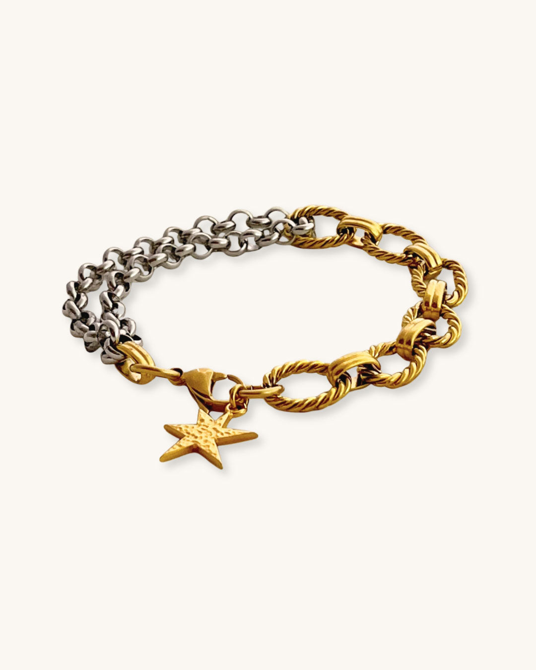 Two chain bracelets, one gold and one silver with a gold charm charm on a light background