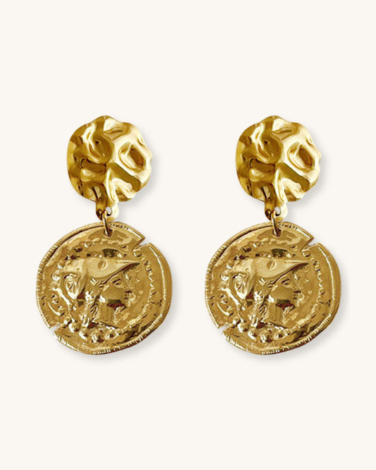 The Athena Coin Earrings, a pair of gold earrings featuring a raised design of Athena's goddess face accents on a coin.