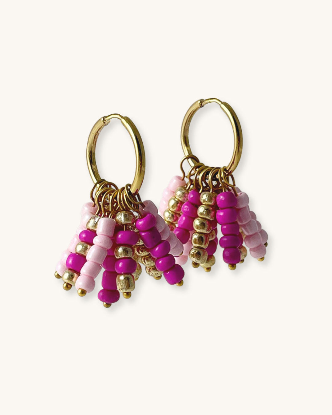 Pair of beaded hoop earrings with pink and gold details on a white background