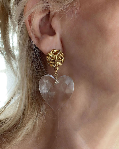 Model wearing a gold Statement Earrings with a large clear acrylic heart 