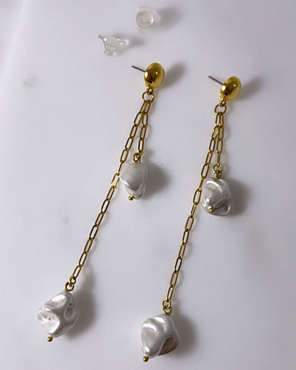 The Long Drop Pearl Shell Earrings, a pair of stud earrings featuring two paperclip chains with shell pearl pendants.
