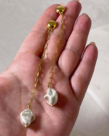 The Long Pearl Shell Earrings, a pair of stud earrings featuring a paperclip chain with a shell pearl pendant.
