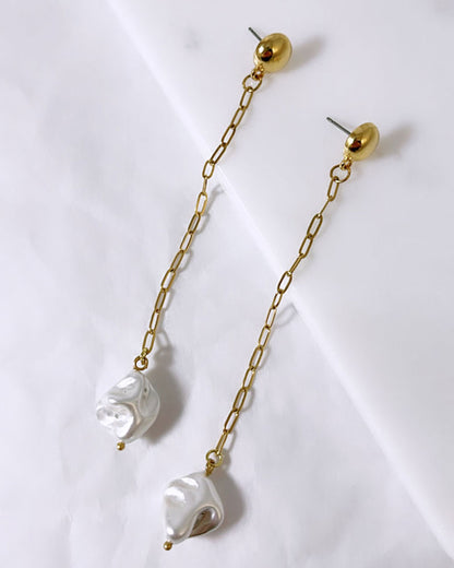 The Long Pearl Shell Earrings, a pair of stud earrings featuring a paperclip chain with a shell pearl pendant.