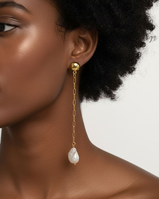 Model wearing the Long Pearl Shell Earrings, a pair of stud earrings featuring a paperclip chain with a shell pearl pendant.