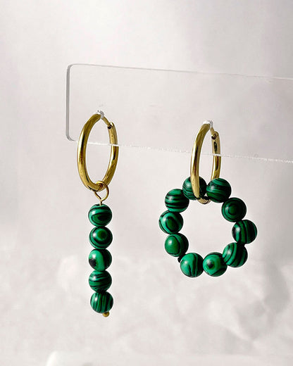 The Malachite Hoop Earrings, a pair of gold hoop earrings featuring malachite stones.