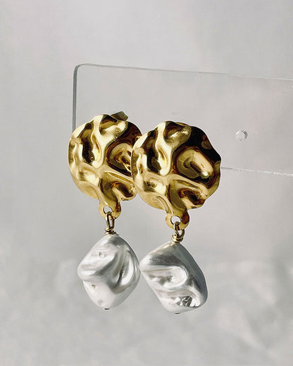 The Pearl Shell Gold Earrings, a pair of gold earrings featuring MOP shell pearls.