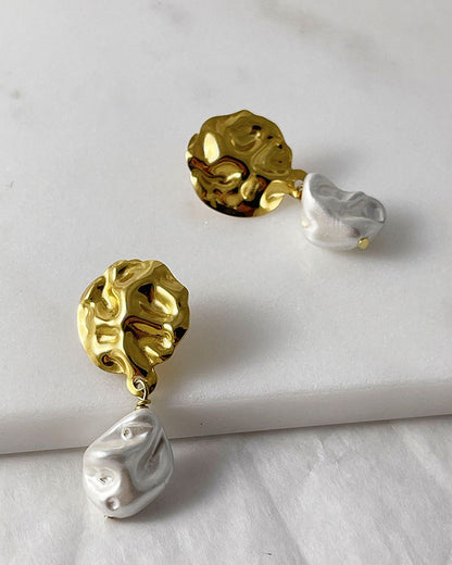 The Pearl Shell Gold Earrings, a pair of gold earrings featuring MOP shell pearls.