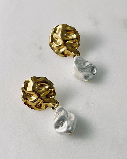 The Pearl Shell Gold Earrings, a pair of gold earrings featuring MOP shell pearls.