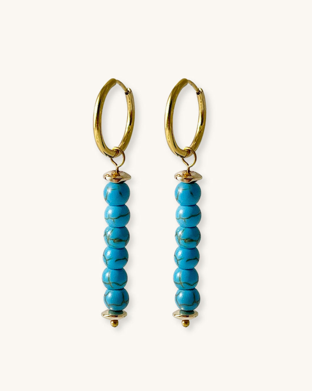 Pair of gold hoop earrings with turquoise bead drops on a white background