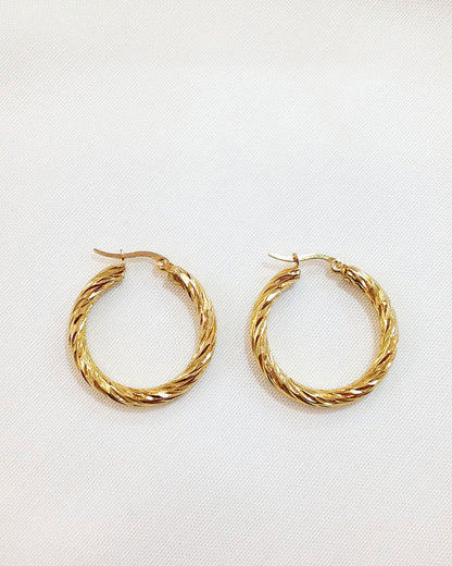 A pair of 30mm twisted gold hoop earrings on a white background.
