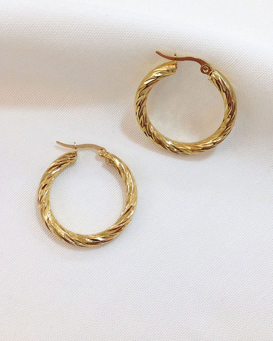 A pair of 30mm twisted gold hoop earrings on a white background.