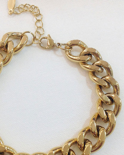 Close-up look of a gold thick Cuban link bracelet