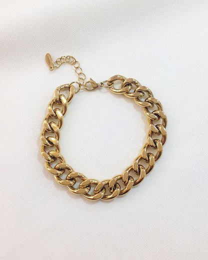 Waterproof thick Cuban link bracelet in gold on a neutral background