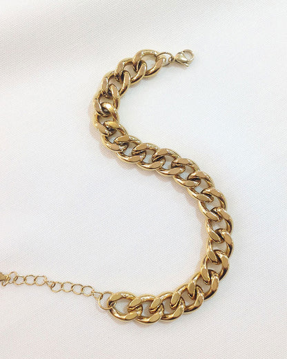 Close-up look of a gold thick Cuban link bracelet