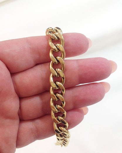 Close-up look of a gold thick Cuban link bracelet