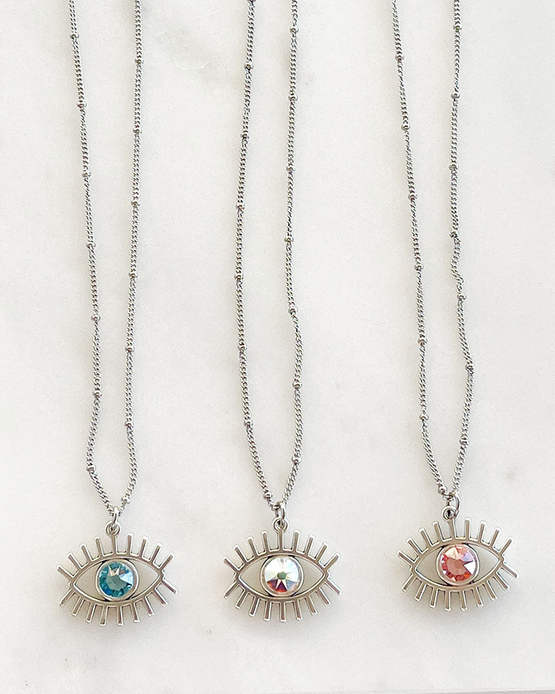 A dainty chain necklace with an evil eye pendant and a Swarovski crystal
