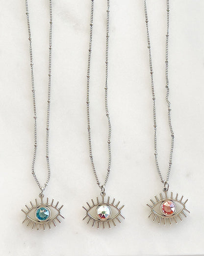 A dainty chain necklace with an evil eye pendant and a Swarovski crystal