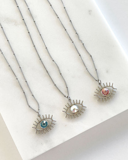 A dainty chain necklace with an evil eye pendant and a Swarovski crystal
