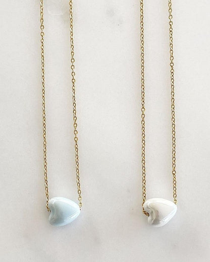 A dainty chain necklace with ceramic heart bead in gold and silver