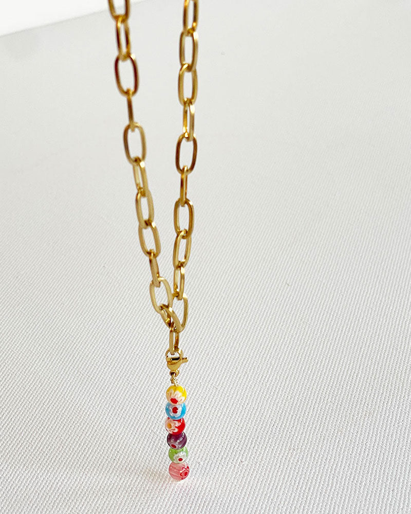 A chunky paperclip chain necklace in gold with a removable murano millefiori beads pendant