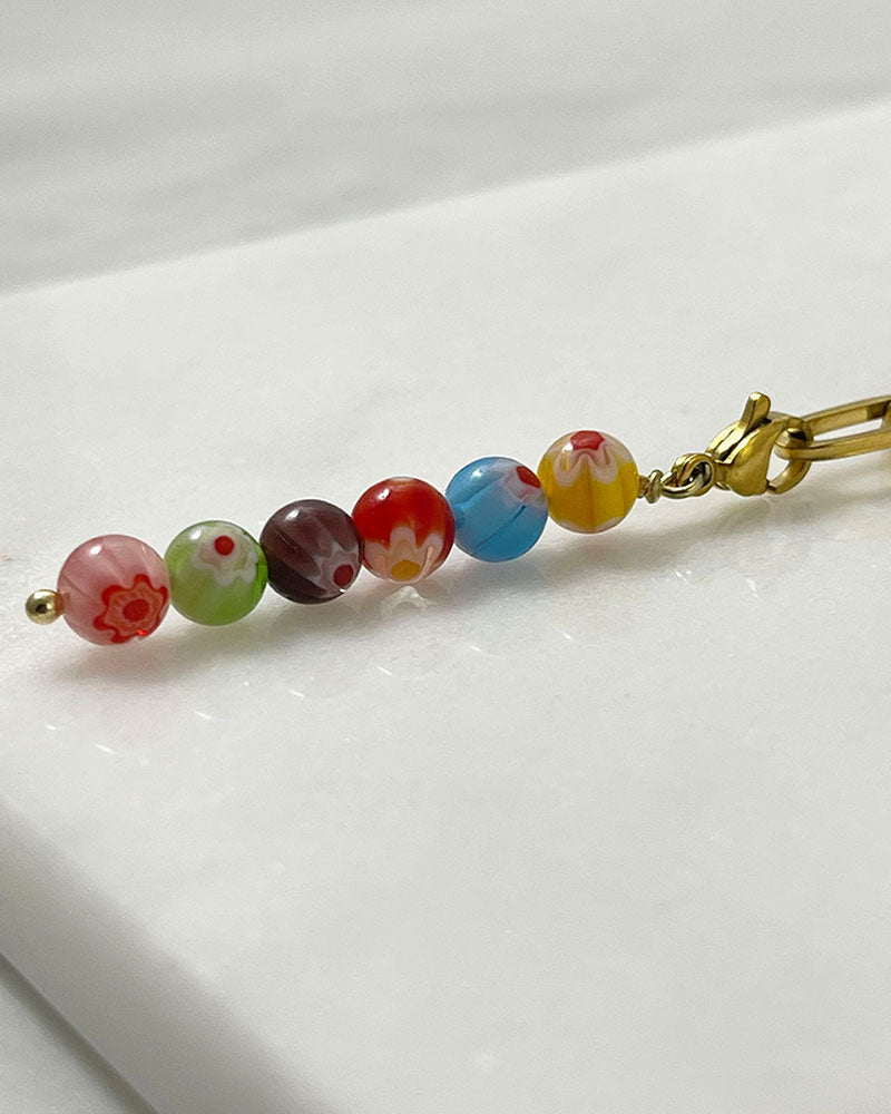 A chunky paperclip chain necklace in gold with a removable murano millefiori beads pendant