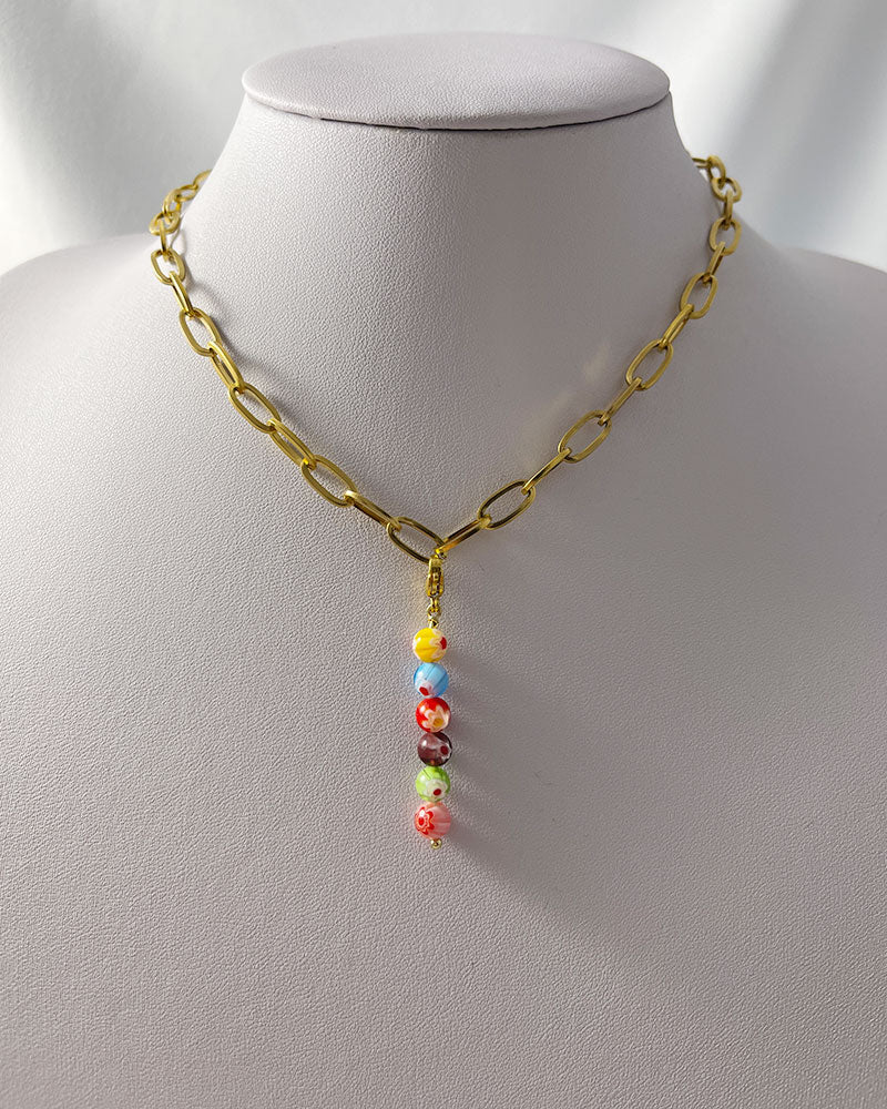 A chunky paperclip chain necklace in gold with a removable murano millefiori beads pendant