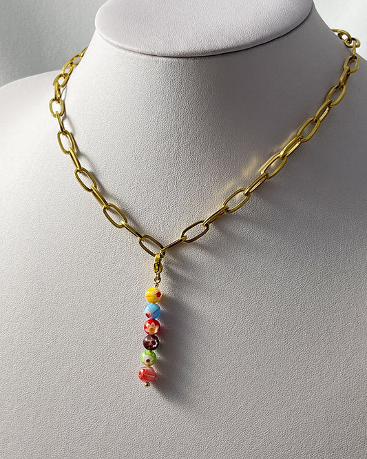A chunky paperclip chain necklace in gold with a removable murano millefiori beads pendant