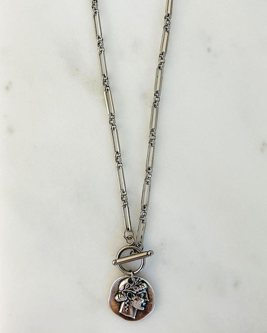 An ancient double sided coin pendant with a paperclip chain and a t-bar toggle closure