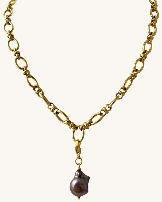 gold chunky chain necklace with a removable large black baroque pearl in the middle