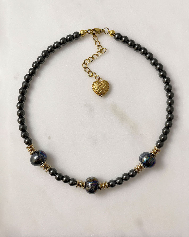 A handmade minimalist necklace with black hematite and ceramic beads