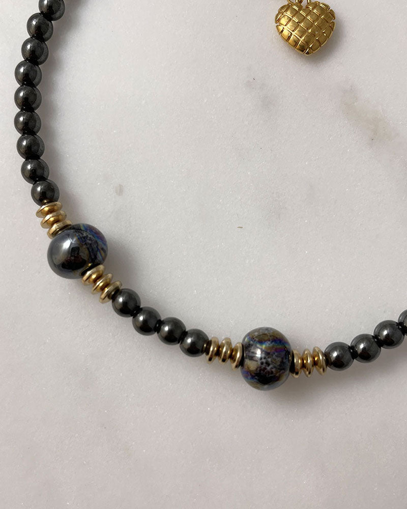 A handmade minimalist necklace with black hematite and ceramic beads