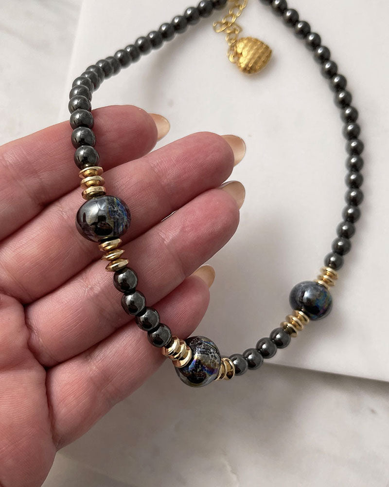 A handmade minimalist necklace with black hematite and ceramic beads