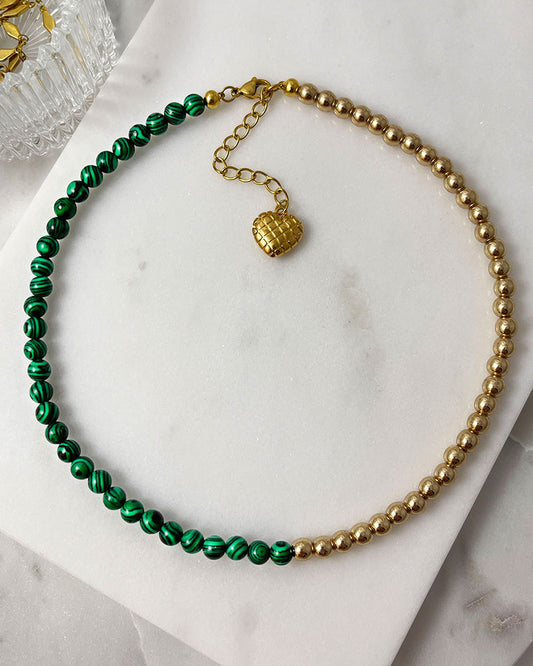 A handmade minimalist necklace with green malachite and gold hematite beads