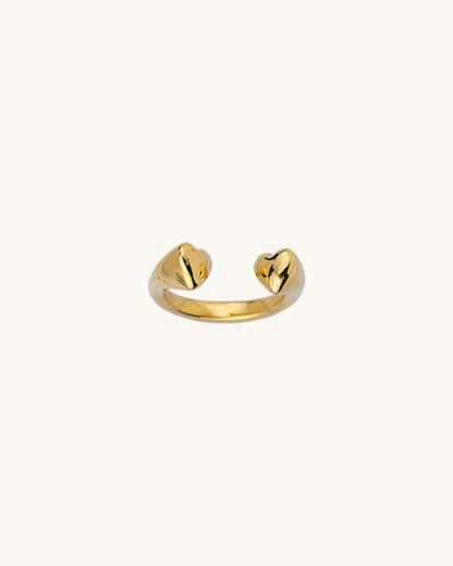 A gold double heart ring with a slightly adjustable band, displayed against a white background.