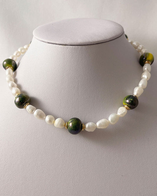 A handmade necklace with freshwater pearls adorned with gold hematite and green ceramic beads