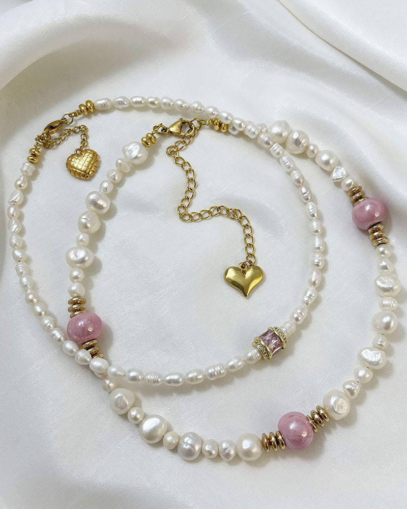 A handmade necklace with freshwater pearls adorned with gold hematite and pink ceramic beads