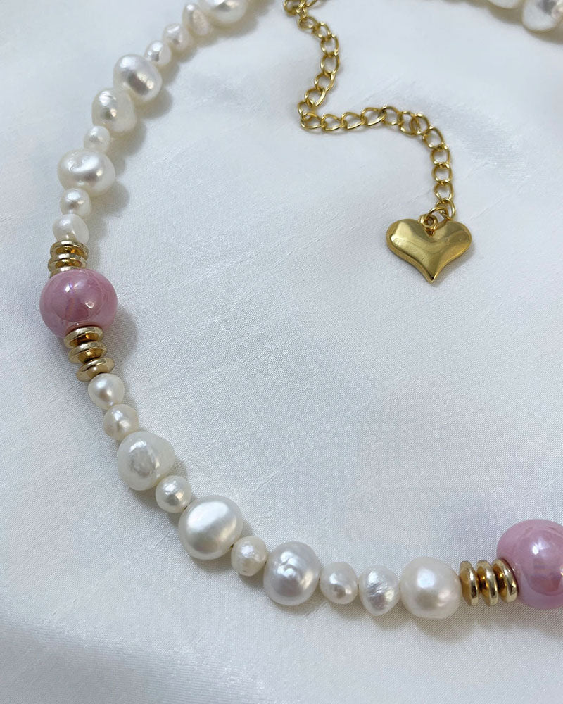 A handmade necklace with freshwater pearls adorned with gold hematite and pink ceramic beads