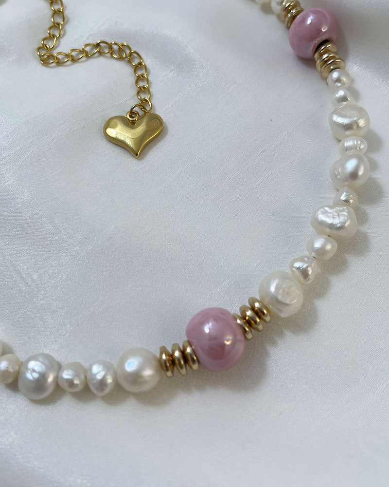 A handmade necklace with freshwater pearls adorned with gold hematite and pink ceramic beads