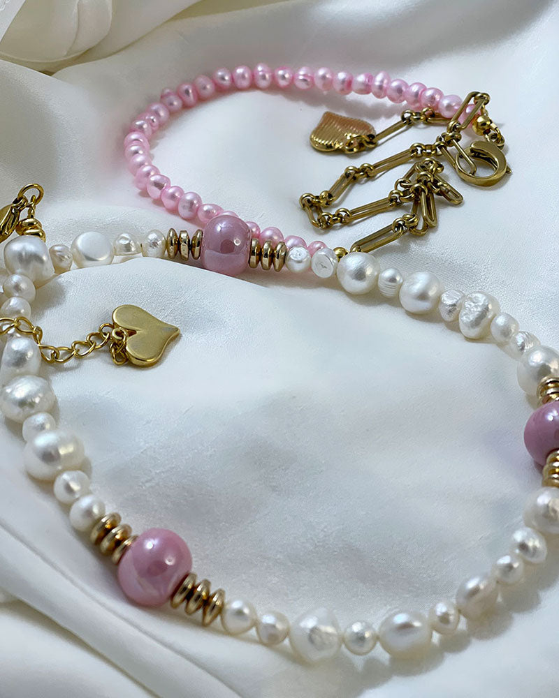 A handmade necklace with freshwater pearls adorned with gold hematite and pink ceramic beads