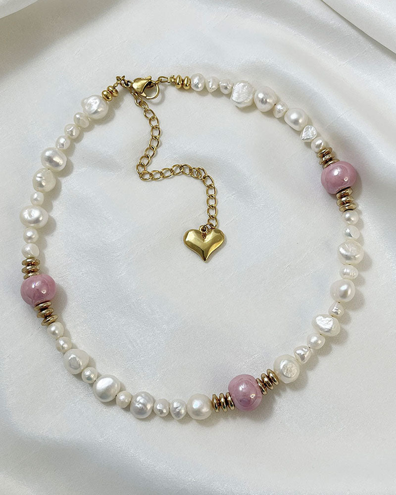 A handmade necklace with freshwater pearls adorned with gold hematite and pink ceramic beads