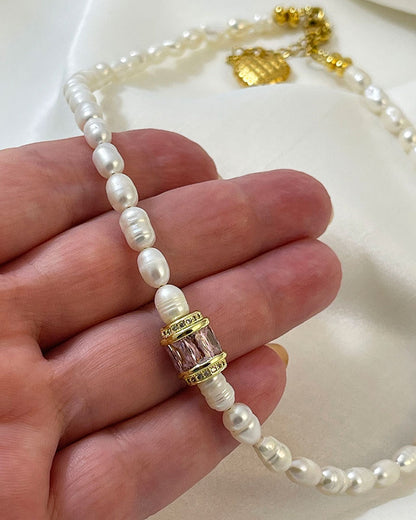 pearl choker necklace with a pink crystal bead in the middle