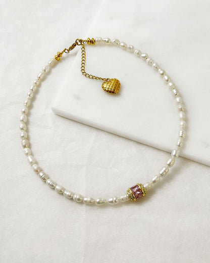 pearl choker necklace with a pink crystal bead in the middle